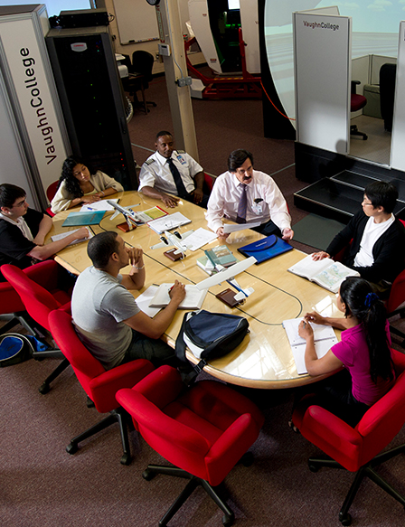 Students and teacher meeting at a table