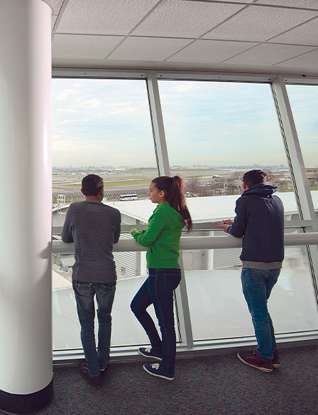 Students looking through a window at an air field