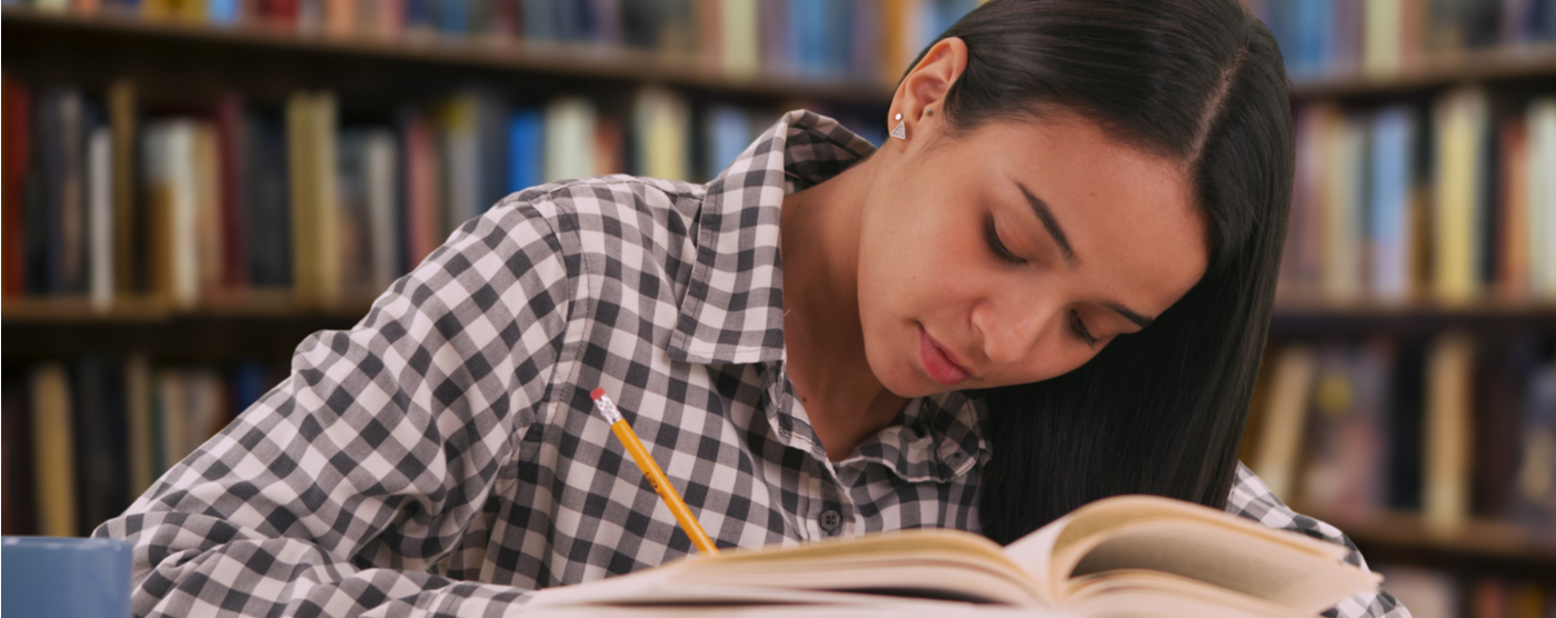 Latina girl studying for final exam in library