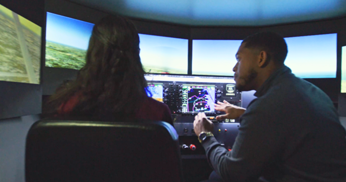 Teacher showing student how to land plane in flight simulator